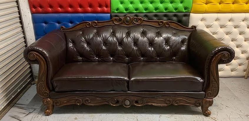 Ornate Chesterfield sofa after professional leather restoration — deep chocolate